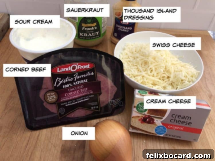 Ingredients laid out for making Reuben dip, including corned beef, Swiss cheese, sauerkraut, and dressings