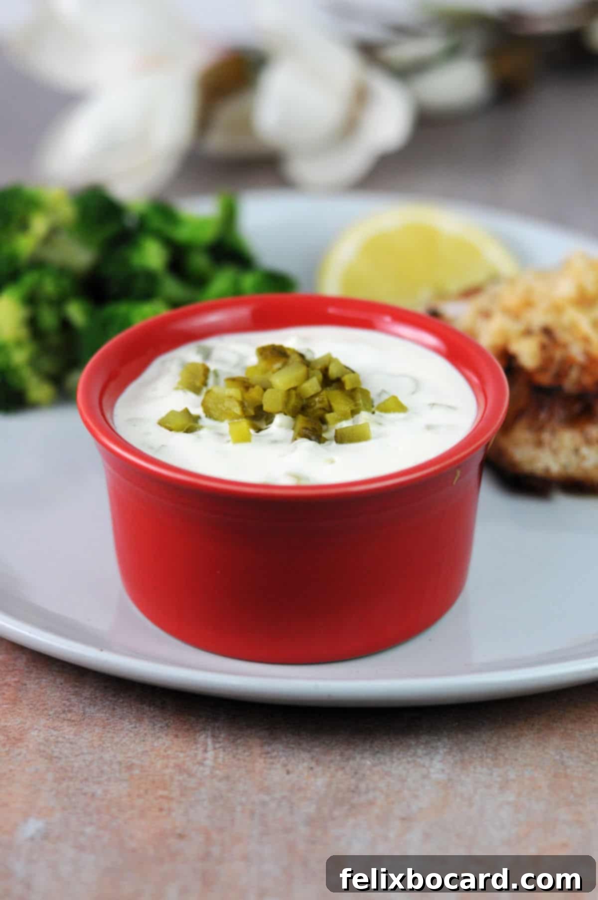 bowl of homemade keto tartar sauce on a plate with fish and broccoli.