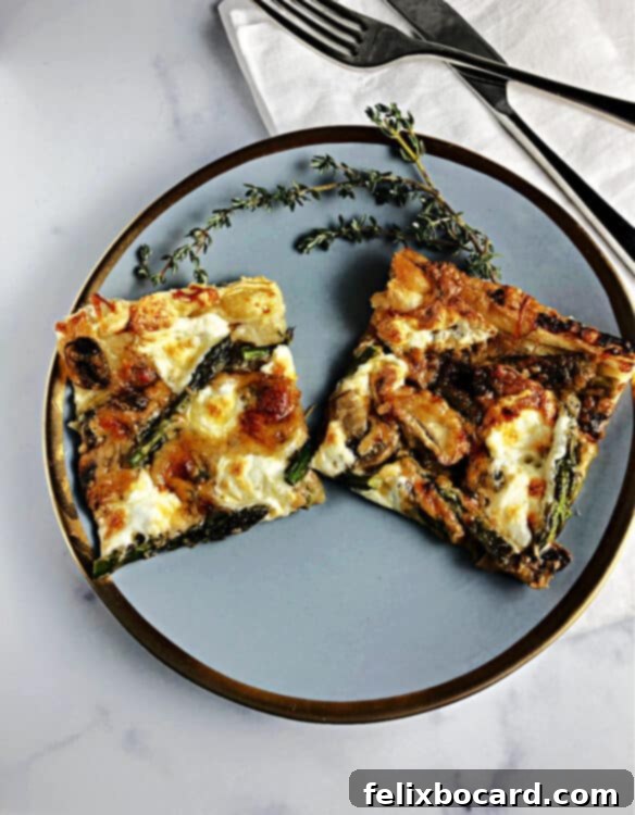 A slice of asparagus and mushroom puff pastry galette on a gold-rimmed plate, highlighting its appetizing presentation