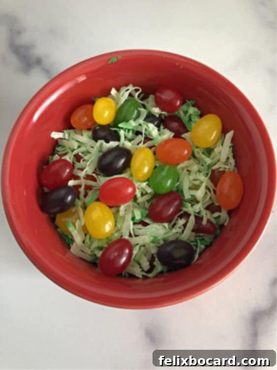 jelly beans on edible easter grass in a small red bowl