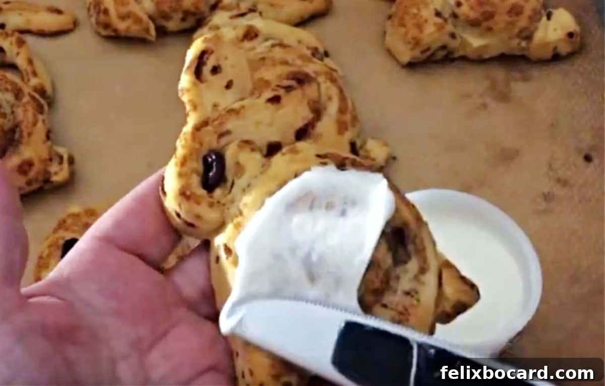 Adding frosting to cinnamon rolls.