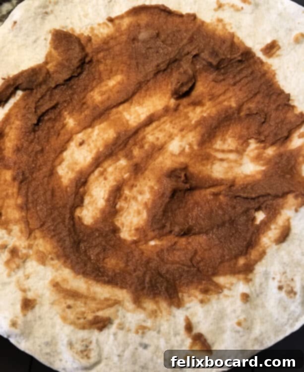 flour tortilla spread with refried beans