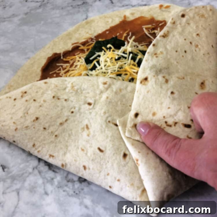 starting to fold the tortilla in toward the middle