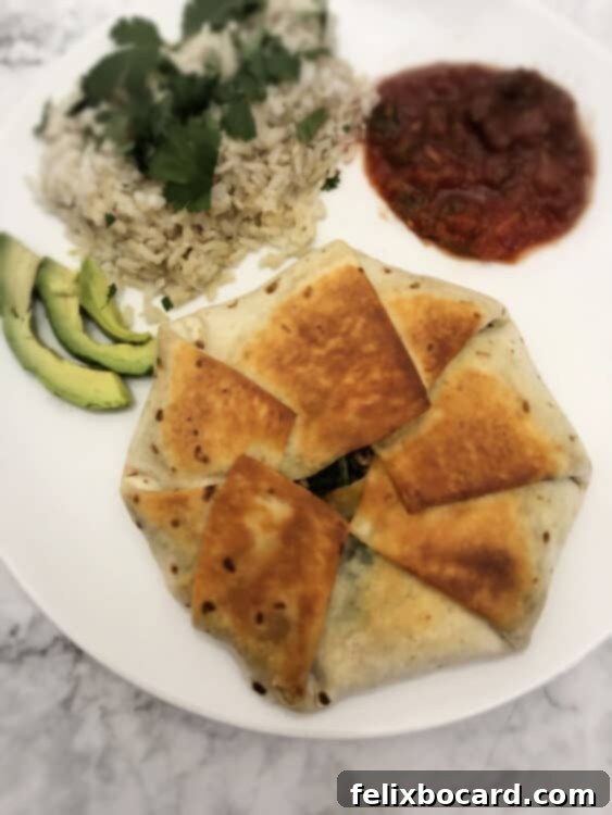 cooked vegetarian crunch wrap on a plate with rice, salsa and avocado