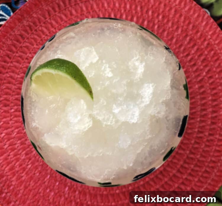 top down view of margarita slush in a glass with a wedge of lime