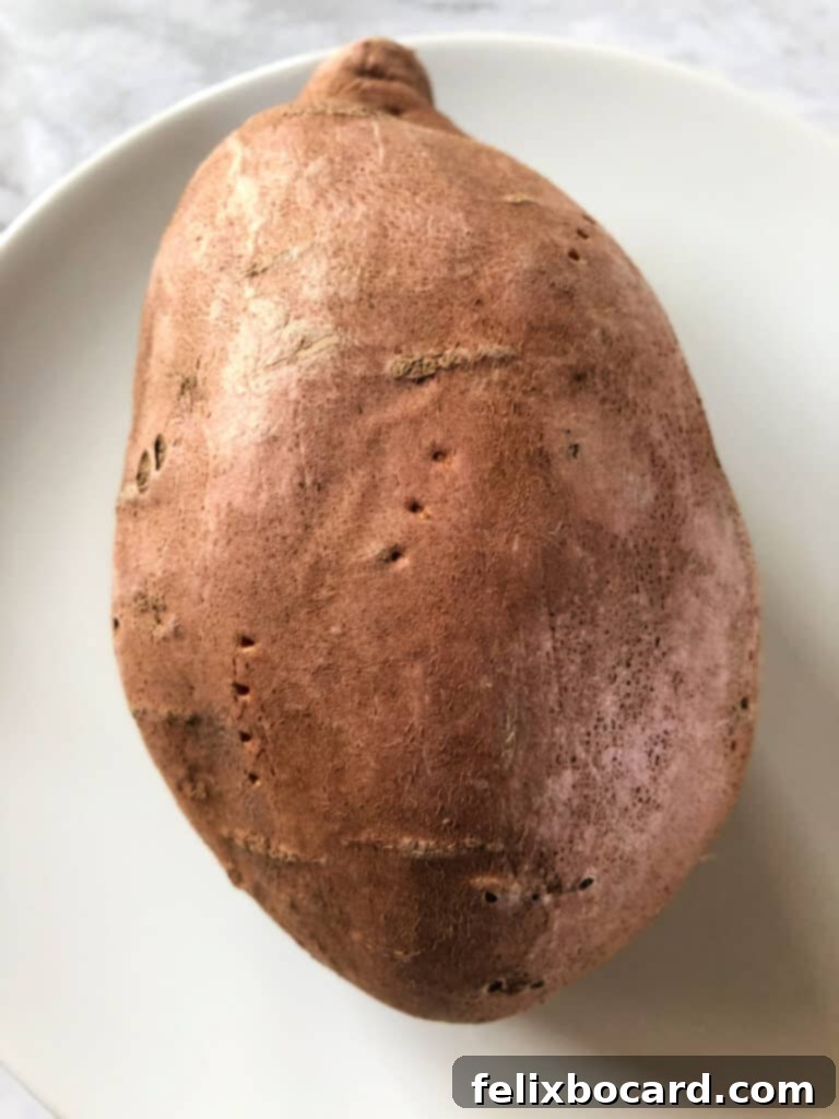 Sweet Potato Boats Made Easy 3 Sweet potato pierced with a fork, ready for microwaving to ensure even cooking.