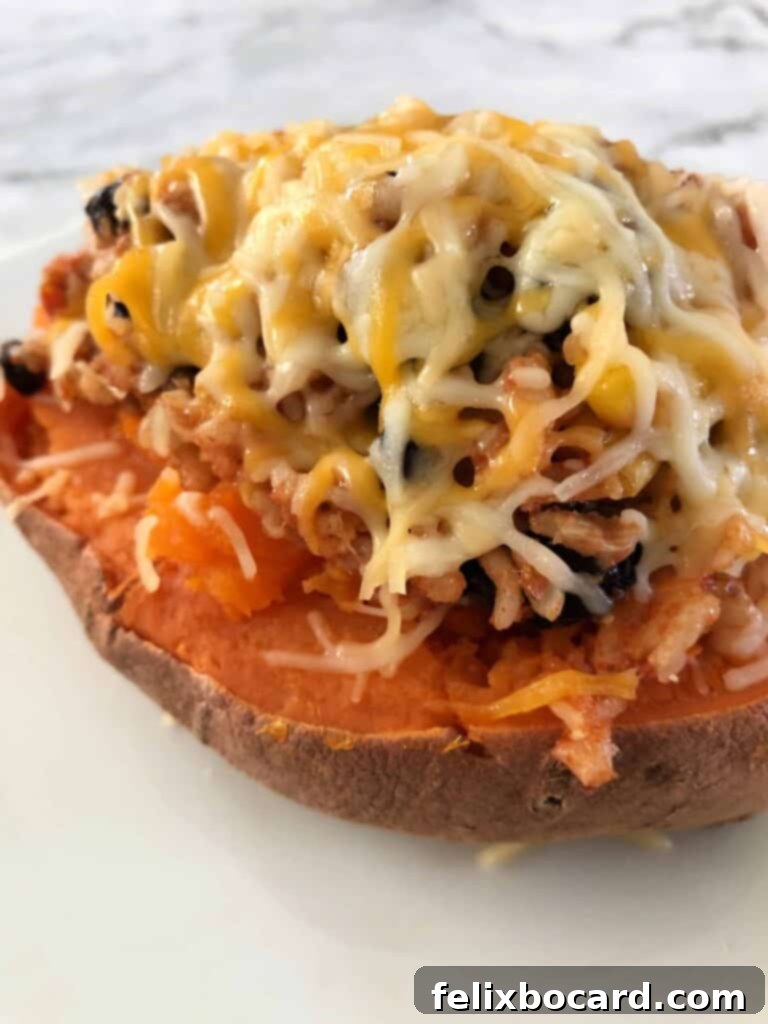 Sweet Potato Boats Made Easy 7 Stuffed sweet potato generously topped with shredded cheese, ready to be melted.