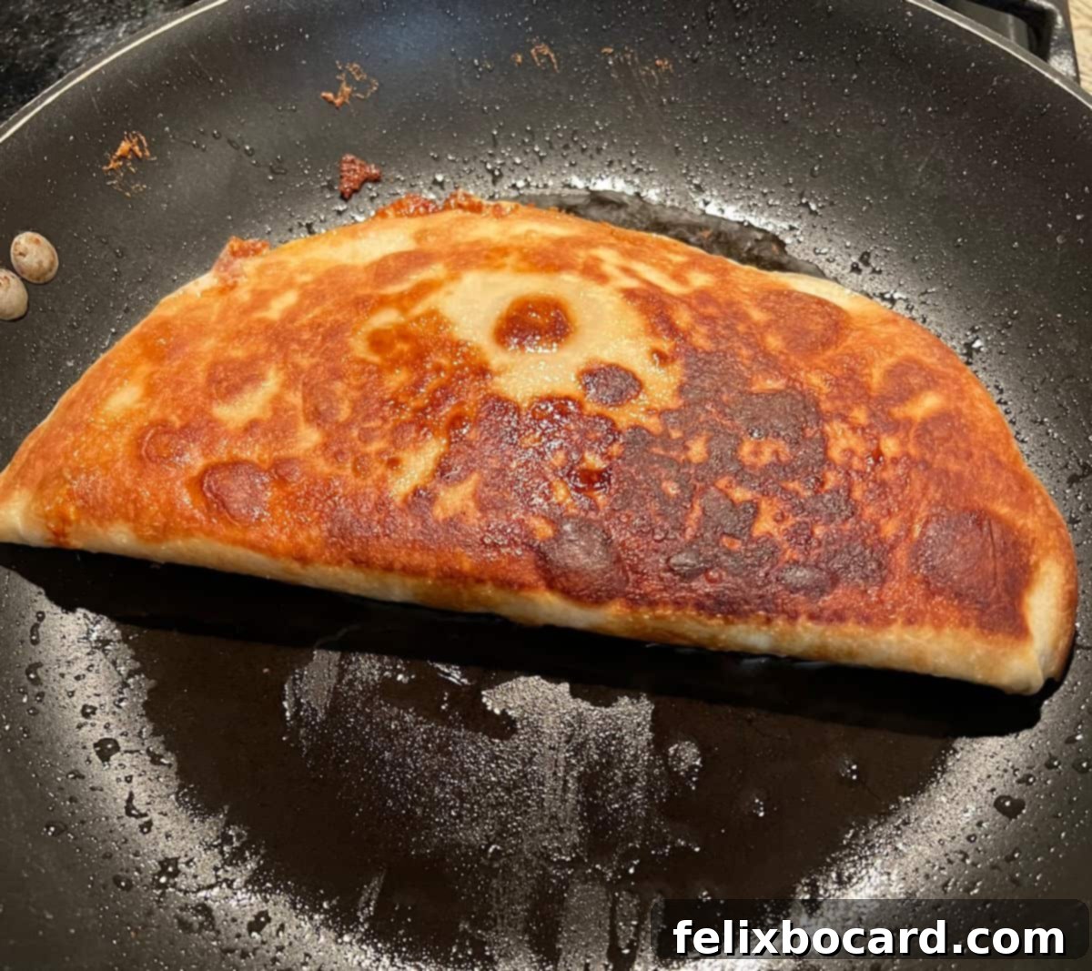 Quesadilla flipped over in the pan to brown the second side.
