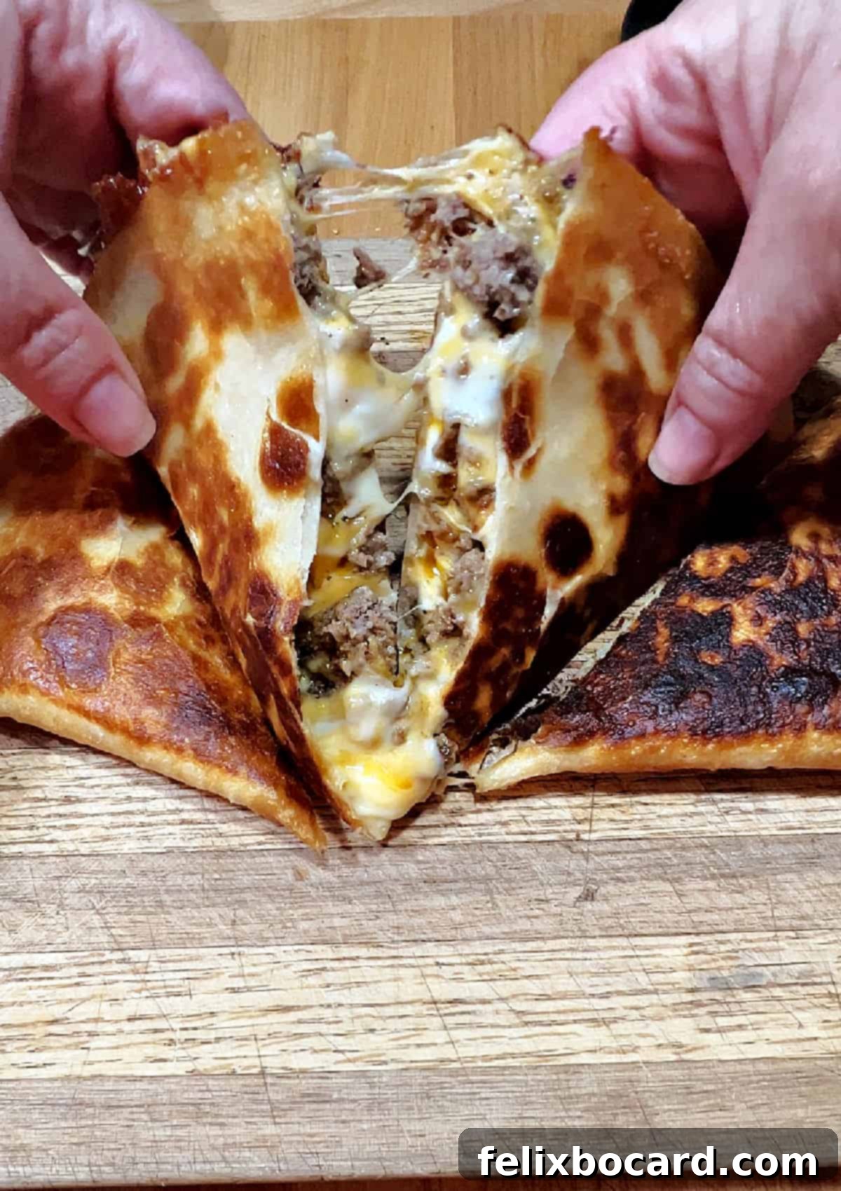 Cut quesadilla opening to show the ground beef and melted cheese inside.