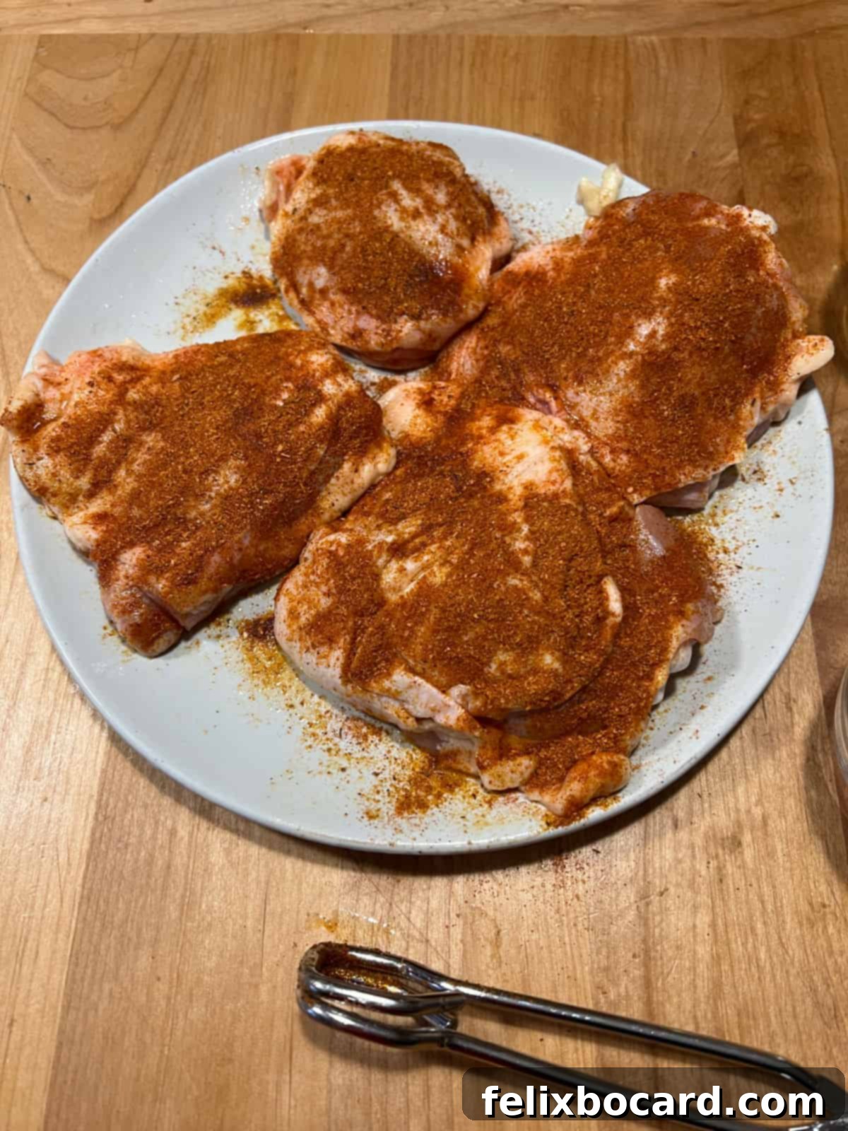 Raw chicken thighs seasoned with a spice blend, ready for air frying.