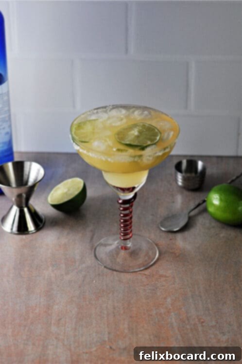 Overhead view of a perfectly crafted keto margarita in a salt-rimmed glass with a lime wedge.