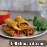 Air fried taquitos on a small plate with sauce in the background