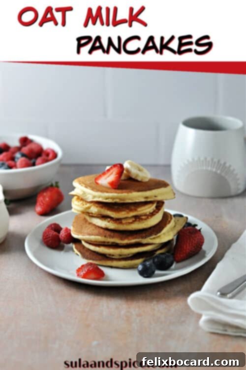 Pinterest pin graphic for fluffy oat milk pancakes, featuring a stack of pancakes with berries and syrup.