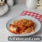 A small plate of spaghetti with pork parmesan and sauce.