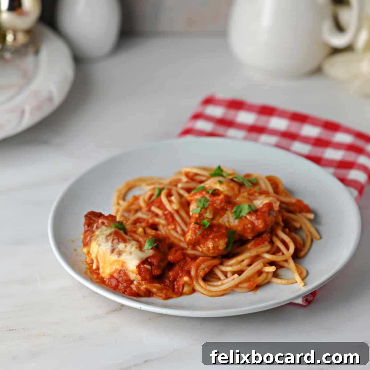 A small plate of spaghetti with pork parmesan and sauce.